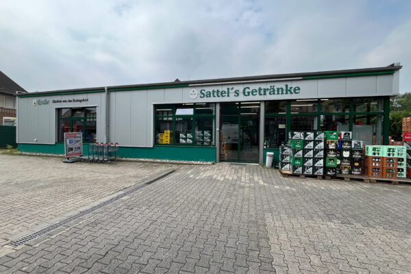 Außenansicht von Sattel's Getränke, einem Getränkemarkt in Altenessen, mit Eingang und Getränkekisten vor dem Laden.