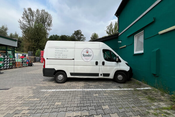 Lieferwagen von Sattel's Getränke, geparkt vor dem Getränkemarkt in Altenessen, mit Adresse und Kontaktdaten auf der Seite.